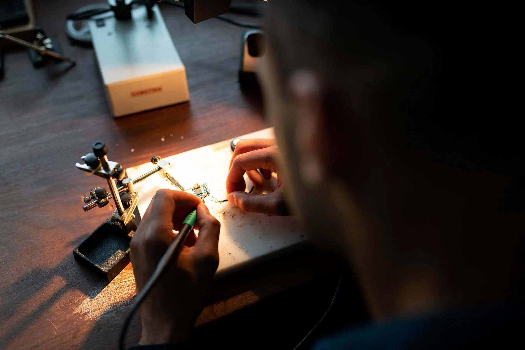 A real electronics workbench with a soldering iron and circuit board