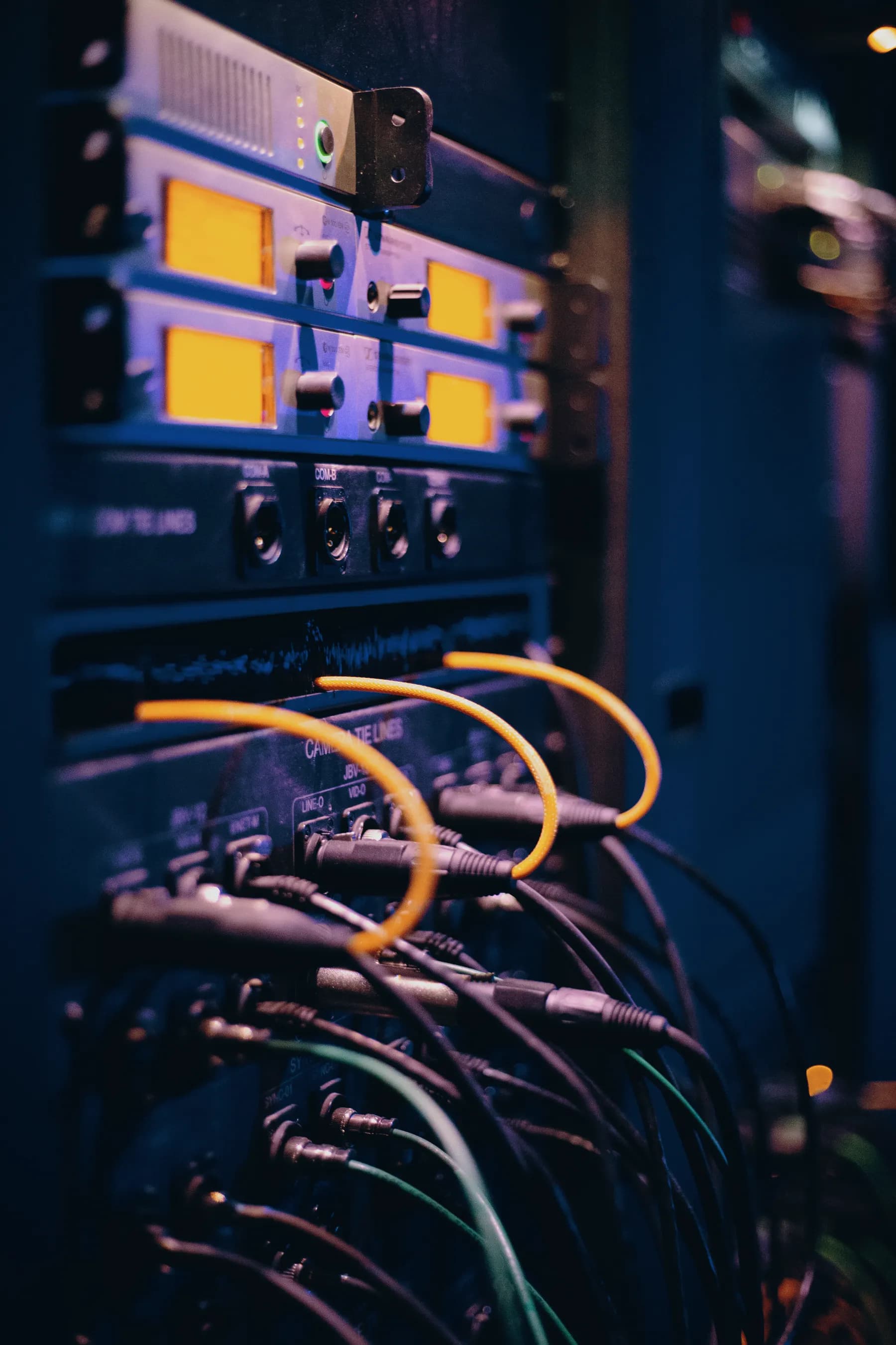 Close-up of cabled rack hardware with orange patch cables.